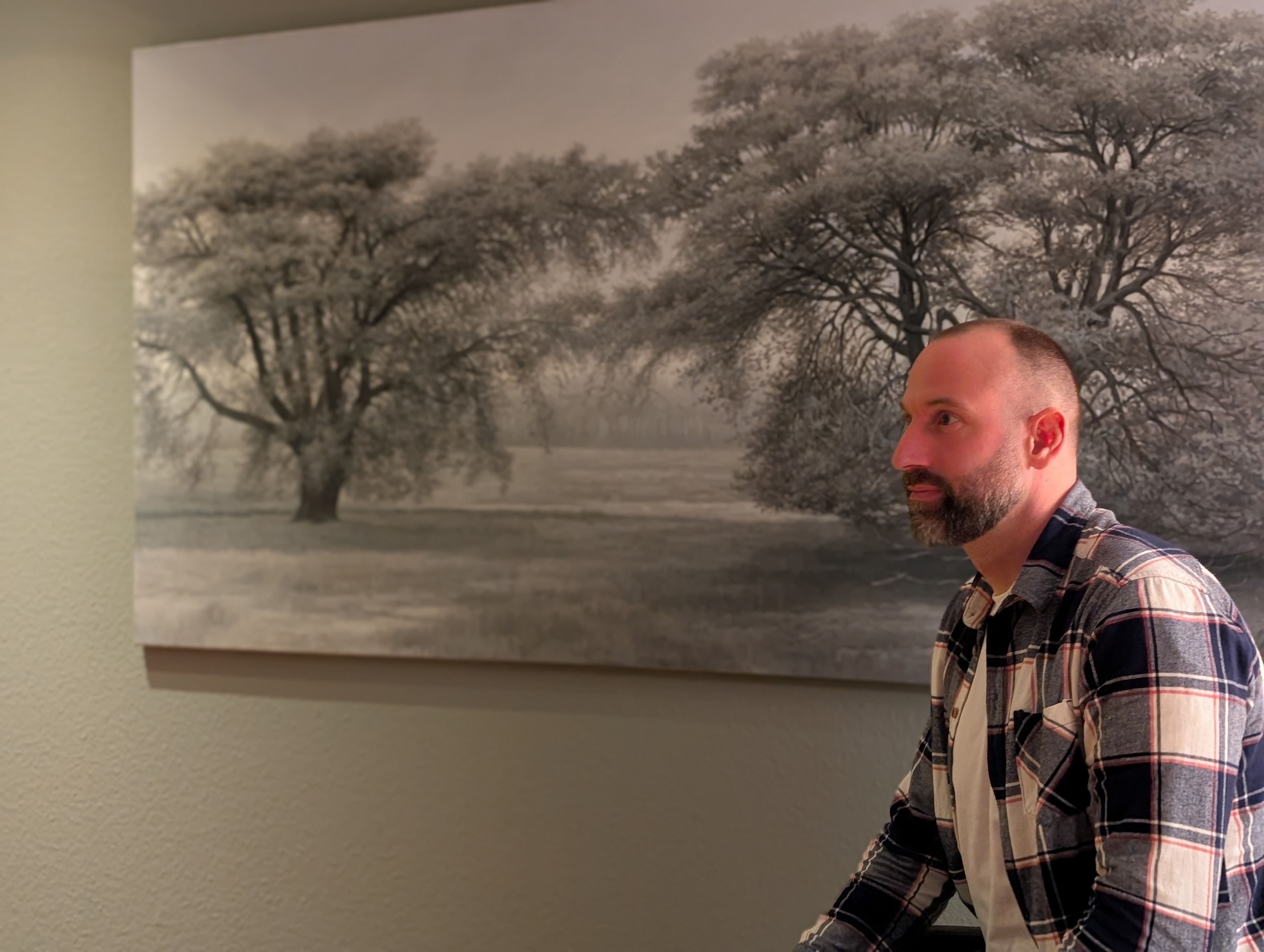 Daniel Jäger vor einem gemalten Baum im Beratungsraum
